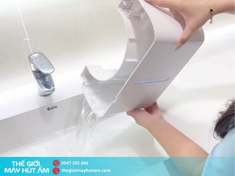 Đổ bình chứa nước thải trước khi vệ sinh máy hút ẩm Kosmen KM-12W